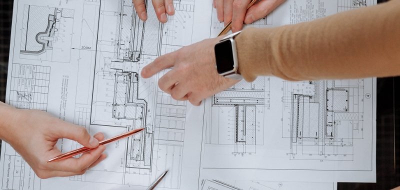 hands working on blueprints